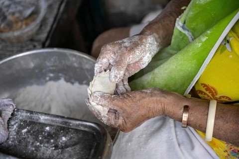 A Thai women preparing traditional pastry to be baked and sold in a Bangkok street market, Thailand