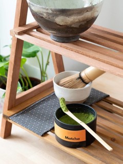 Matcha powder in a scoop with whisk and bowl ready for a traditional tea ceremony