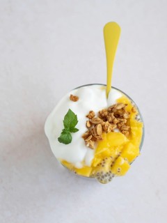 Healthy chia seed pudding with fresh mango, creamy yogurt, and crunchy granola, topped with mint