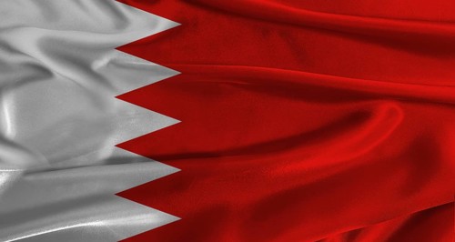 Flag of Bahrain with fabric textured background. Close up of National flag of Bahrain with