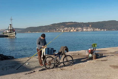 Canakkale, Turkey. February 18th 2022 A Turkish fisherman on the pier at Canakkale, with the