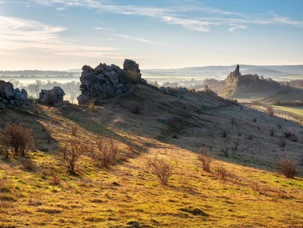 Rock formations in the Teufelsmauer nature reserve in morning light and morning fog, near