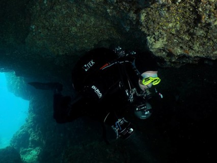 Diver, cave diver, in the dark area of an underwater cave wears diving equipment. Fraskeric dive