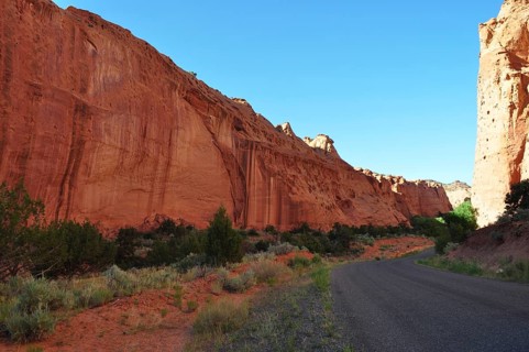 A narrow road snakes through impressive red rock walls in a dry desert landscape, Grand Staircase
