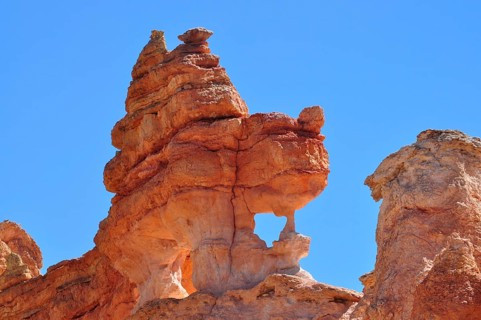 Close-up of sculptural, natural red rock formation under blue sky, Bryce Canyon National Park,