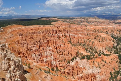 Wide rocky landscape under cloudy sky with orange canyons, Bryce Canyon National Park, Utah, USA