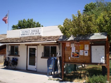 Small post office building with a US flag and attached information board in a quiet village,