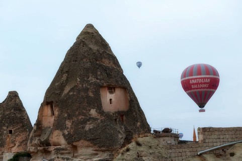 Goreme, Cappadocia, Turkey. October 13th 2018 Hot air balloons rise of traditional cone shaped rock