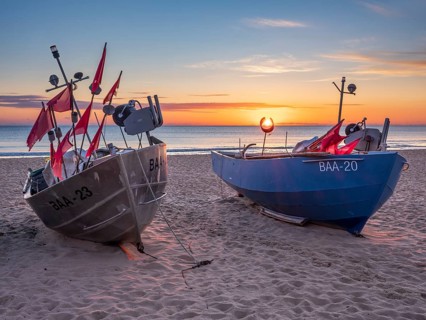 Fishing boats with red flags on fishing beach on the Baltic Sea at sunrise, Baabe, Mönchgut