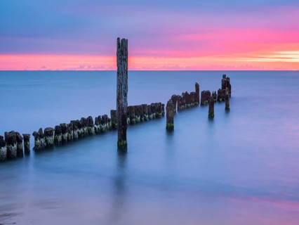 Sunrise on the Baltic Sea beach with old grouse at the Baltic Sea resort of Breege-Juliusruh,