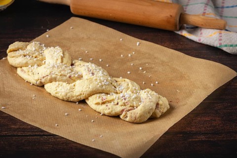 Braided yeast braid with sugar on baking paper