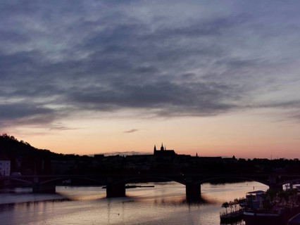 Pink sunset over the Vltava with silhouettes of Charles Bridge and Hradcany, Prague, Czech Republic