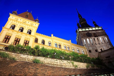 Romania, hour tower and the cultural house at the blue hour in the historic old town of Sighisoara,