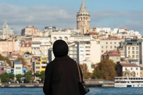 Istanbul, Turkey. November 10th 2022 A Muslim women looks out over the Golden Horn towards the