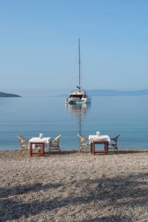 Bodrum, Mugla, Turkey. April 22nd 2022 Restaurant tables on the beach with a Catamaran moored in