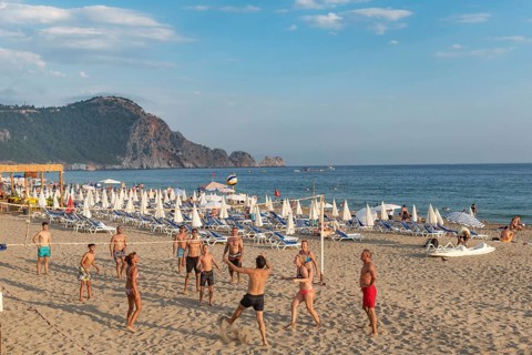 Holiday makers playing volleyball on Cleopatra Beach in the Turkish holiday resort town of Alanya