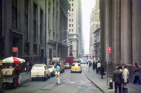 Yellow taxi cab driving down Wall Street toward Broadway, Financial District of Lower Manhattan,