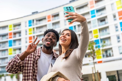 Multiethnic couple enjoying leisure time together, standing outdoors in front of a colorful modern