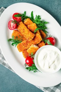 Fried fish nuggets, with white sauce, arugula and cherry, no people