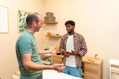 Two men engaging in a friendly and professional conversation about health and wellness, consulting