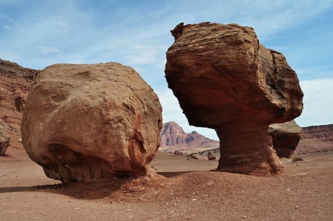 Two large rocks stand side by side in a desert landscape with a red rock backdrop, Grand Canyon