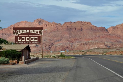 Lodge on a road in the desert in front of a rocky landscape with clouds in the sky, Grand Canyon