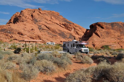 RV on campground in desert landscape with large red rocks and sparse vegetation, Valley of Fire