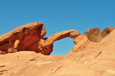 Majestic red sandstone arch under clear blue desert sky, Valley of Fire State Park, Nevada, USA