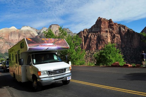Motorhome on a road in front of impressive mountain panorama under blue sky, Zion National Park,
