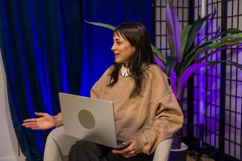 Woman presenting ideas from a modern content creation studio, smiling and gesturing while recording