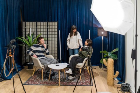 Content creators producing new social media video, with two people sitting and discussing while a