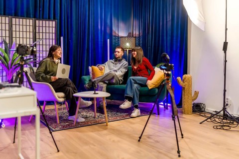 Group of young content creators smiling and interacting while recording a podcast or video