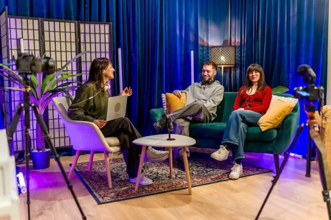 Three young content creators engaging in a conversation, recording a podcast or social media video