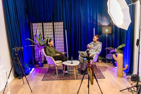 Young diverse people recording a social media podcast in a professional studio, creating digital