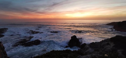 Sunset over the sea, gentle waves and rocks in a tranquil atmosphere, hiking on the Fisherman's