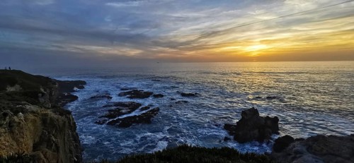 The golden sun sets over the vast sea, illuminated by bright clouds, hiking on the Fisherman's