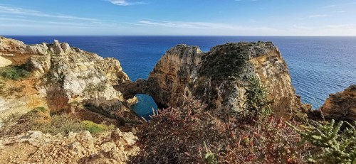 Archway, vast rocky landscape on the edge of the sparkling blue ocean, Lagos, Algarve, Portugal