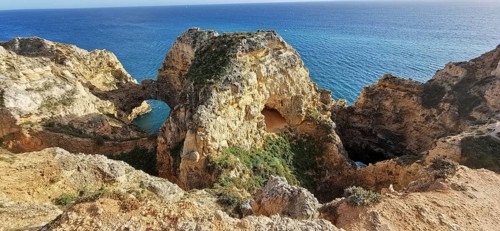 Archway, dramatic rock formations overlooking the calm blue sea, Lagos, Algarve, Portugal