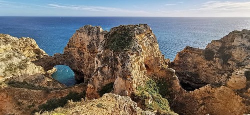 Archway, Dramatic rock formations overlooking the vast ocean under blue sky, Lagos, Algarve,