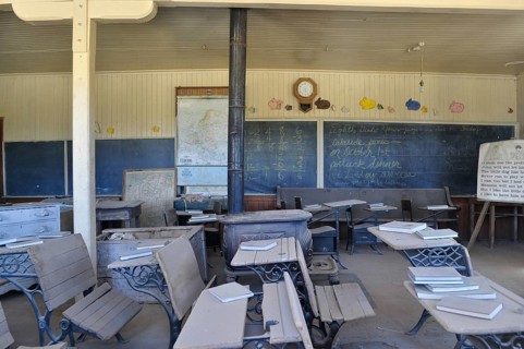 An old abandoned schoolroom with antique benches, chalkboards and open books, Bodie Ghost Town,