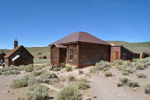 Abandoned wooden houses in the middle of a sandy and dry landscape, Bodie Ghost Town, California,