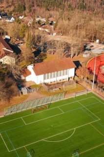 Aerial view of a soccer field with adjacent grandstand and surrounding trees, Wimberg, Calw,