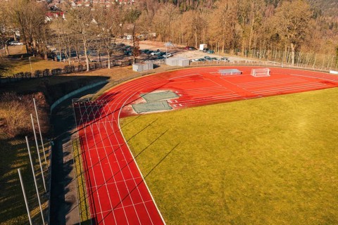 Sports field with red track and shade, surrounded by trees and green space, Wimberg, Calw, Germany
