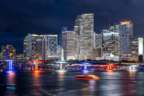 Miami skyline with high-rise real estate in downtown by the ocean at night in Miami, USA