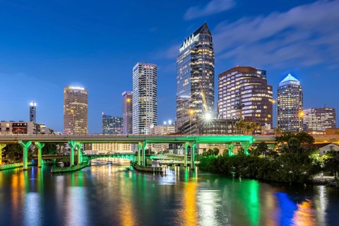 Tampa skyline with skyscrapers and bridge over Hillsborough River at night in downtown Tampa, USA