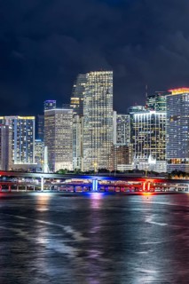 Miami skyline with high-rise real estate in downtown by the ocean at night in Miami, USA