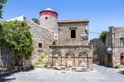 Ottoman fountain and windmill in the historic old town from the Middle Ages on the island of