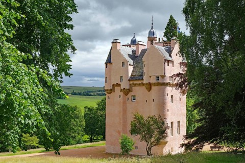Pink castle surrounded by green countryside and trees, Craigievar Castle, Aberdeenshire, Scotland,
