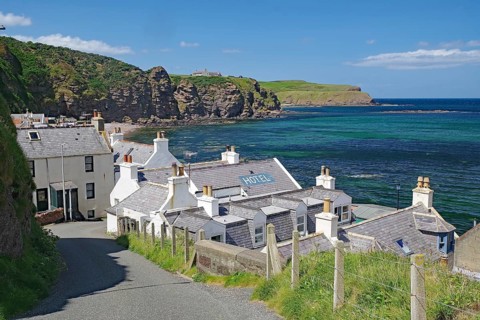 Village with hotel on coast with dramatic cliffs and blue water, Local Hero, Pennan, Aberdeenshire,