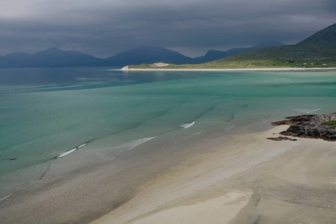 Wide sandy beaches under dark skies with calm seas and mountains, Outer Hebrides, Hebrides, Isle of